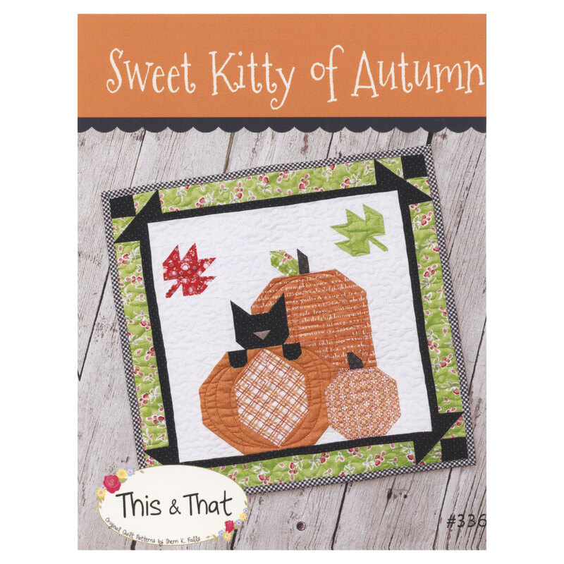 Front of Sweet Kitty of Autumn pattern featuring finished mini-quilt displayed on a wooden table.