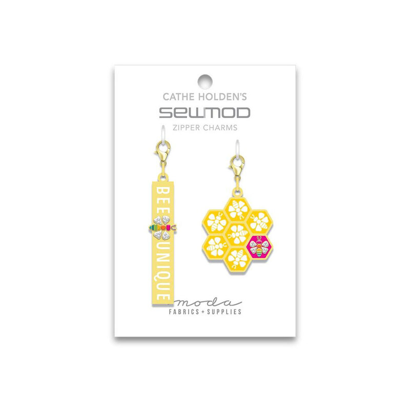 A white tag with a Bee Unique charm and a honeycomb charm