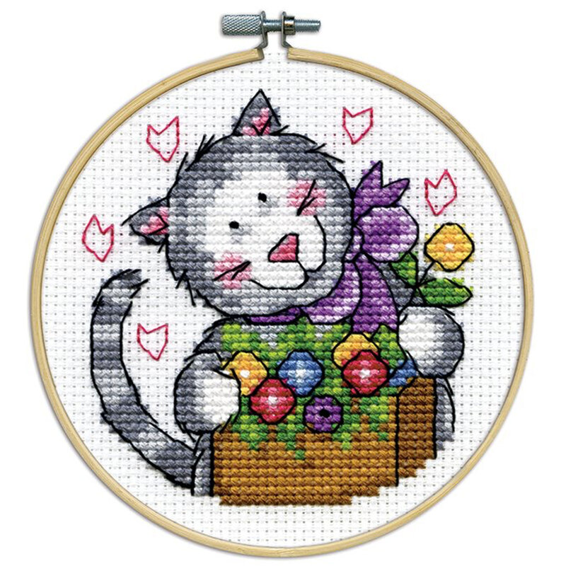 A closeup of the finished Kitty cross stitch inside a wooden hoop isolated on a white background.