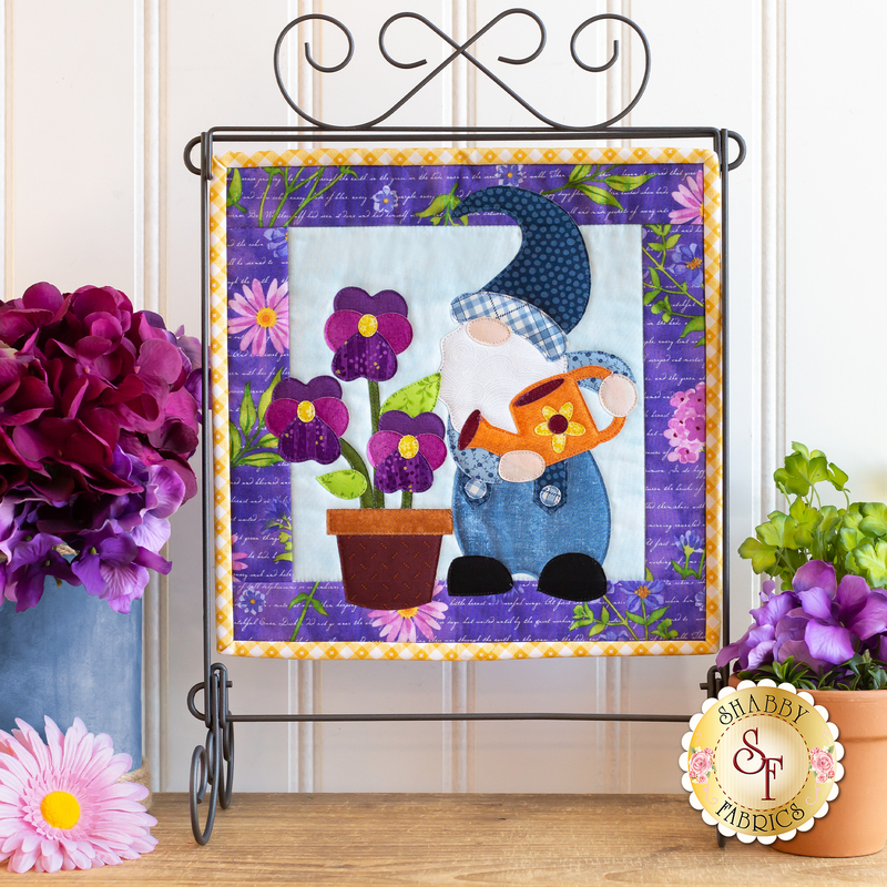 The completed gnome project for May, displayed on a craft holder and staged with coordinating decor.