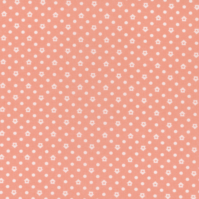Peach colored fabric with a white house and dot pattern