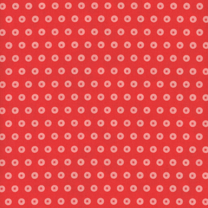 Red fabric with neat rows of tonal circles with asterisks in the center.