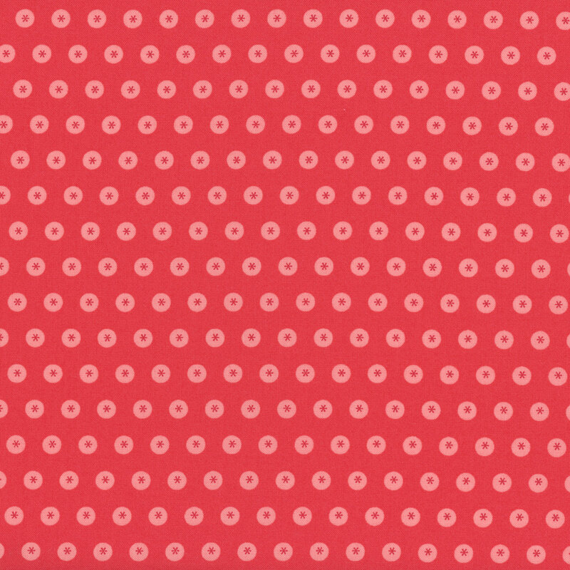 Red fabric with neat rows of tonal circles with asterisks in the center.