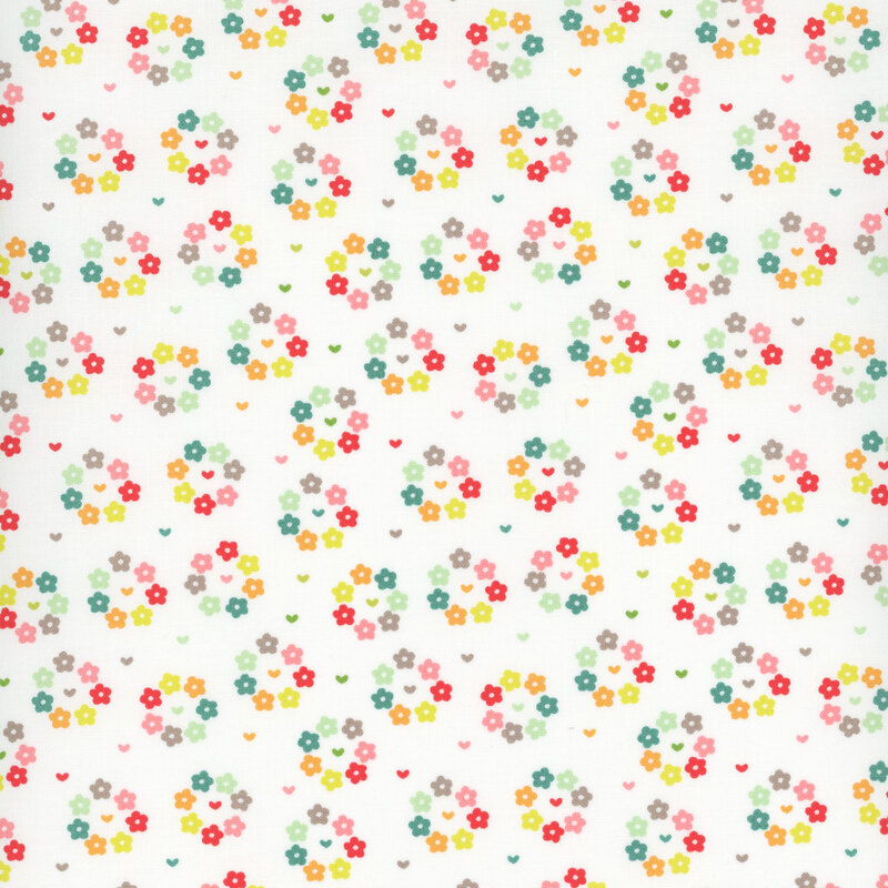 White fabric with small multicolored hearts surrounded by rings of multicolored flowers.