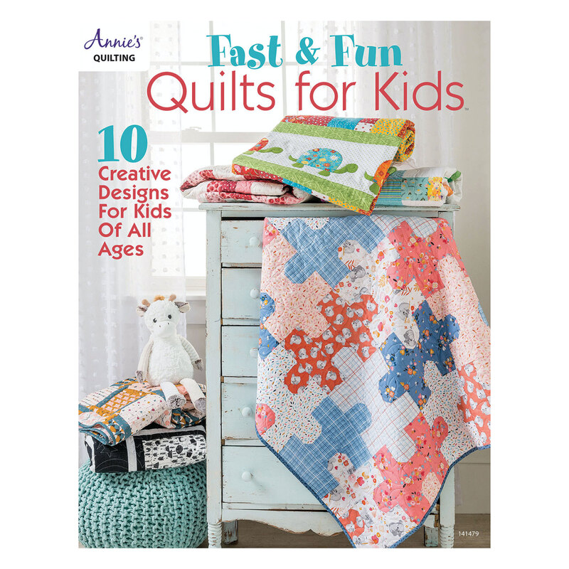The front of the Fast & Fun Quilts for Kids book showing one of the completed quilts coming out of a child's dresser drawer and surrounded by children's decor with 3 other quilts from the book folded on the dresser.