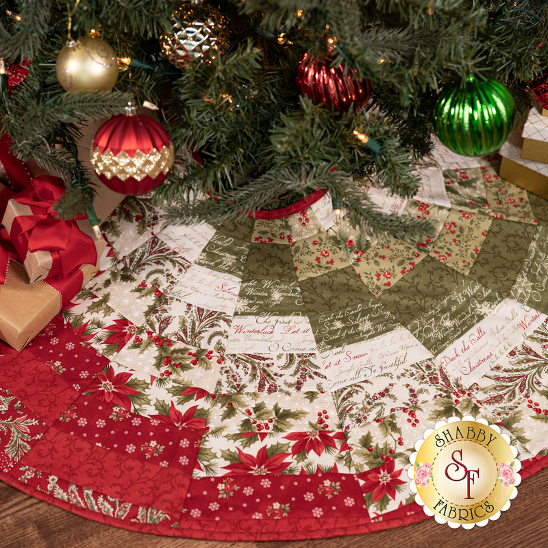 A shot of the completed Bargello tree skirt staged under a decorated Christmas tree and kraft paper wrapped presents.