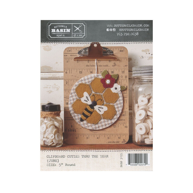 Front cover of pattern showing completed project staged on a clipboard and surrounded by coordinating decor.