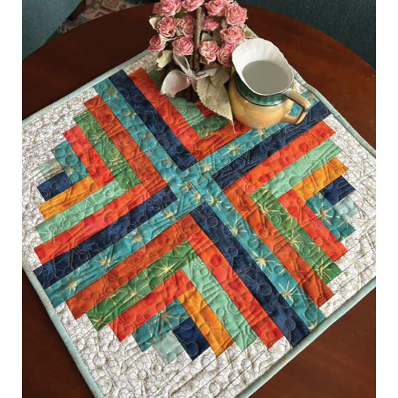 The finished project in orange, teal, blue, and green, staged on a wood tabletop with decor.