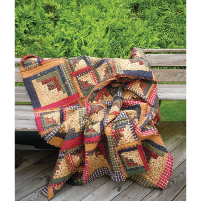 The finished project in cream and earthtone blue, red, and green, staged outdoors on a wood bench.