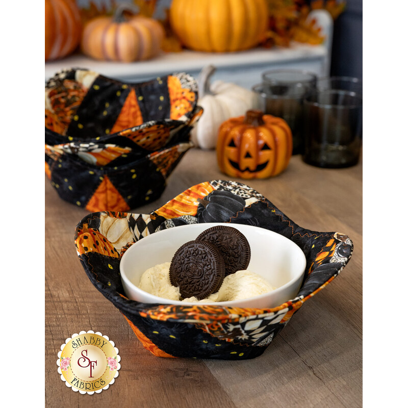 A decorative fabric bowl of vanilla ice cream and cookies, surrounded by coordinating decor and other bowl cozies