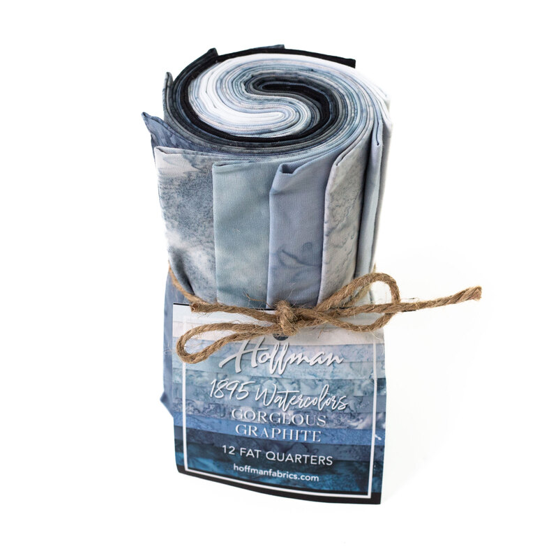 Rolled fabric bundle labeled Gorgeous Graphite, featuring 12 fat quarters in gray and light blue tones.