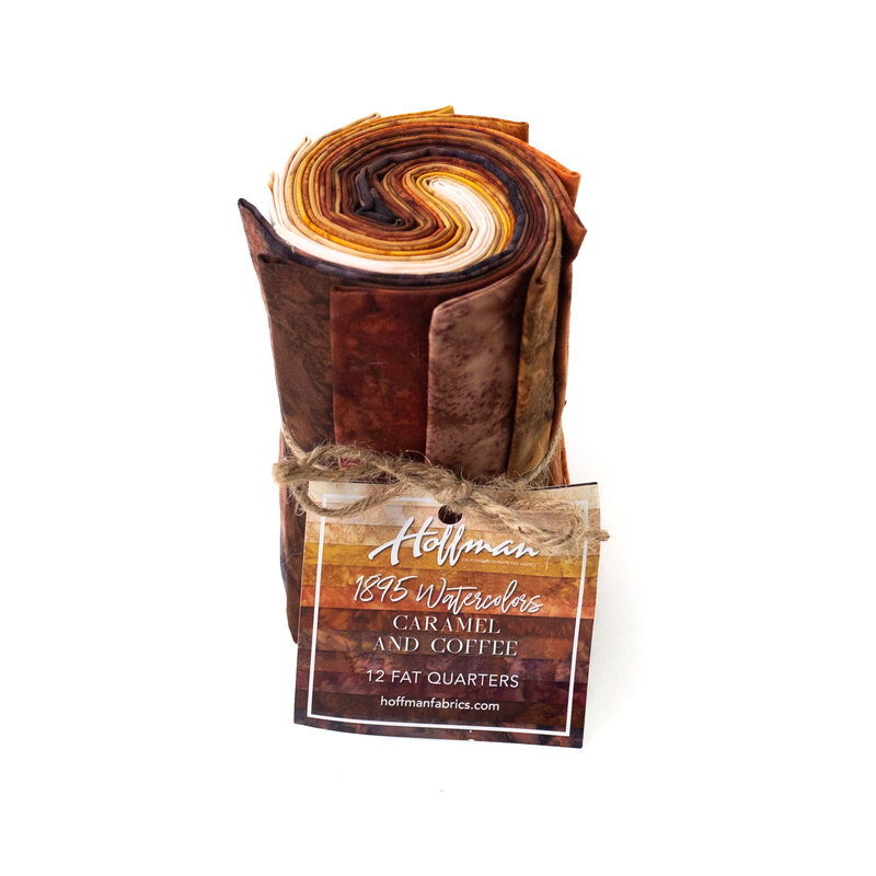 Rolled fabric bundle labeled Carmel and Coffee, featuring 12 fat quarters in brown tones.