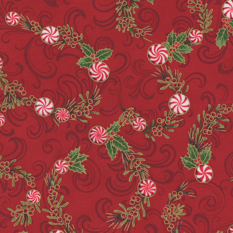 Red fabric featuring swirling patterns of green holly leaves and red-and-white peppermint candies.