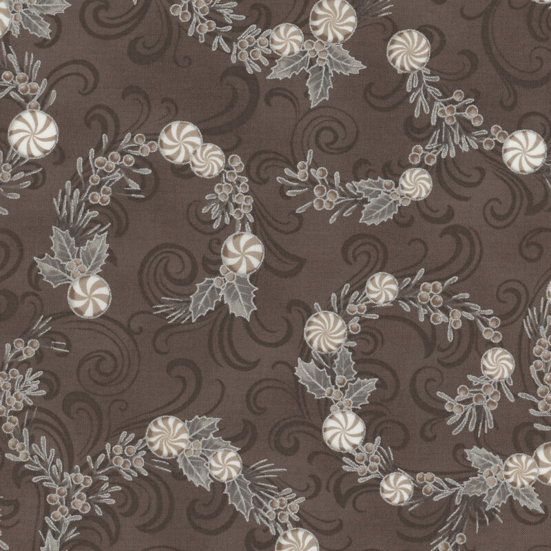 Patterned fabric featuring swirls of holly leaves, berries, and peppermints on a dark background.