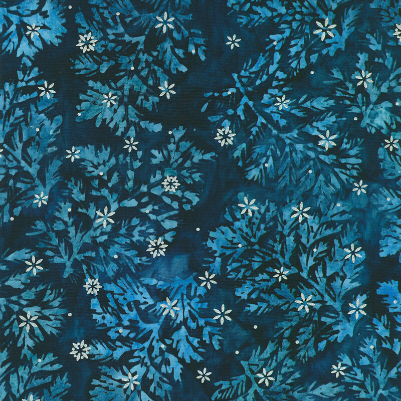 Navy blue batik fabric with lighter blue mottled sprigs and silver metallic snowflakes scattered throughout.