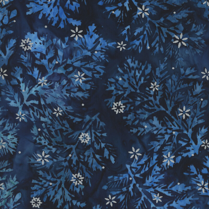 Navy blue batik fabric with lighter blue mottled sprigs and silver metallic snowflakes scattered throughout.