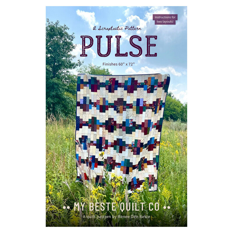 The front of the Pulse pattern featuring the finished quilt being held up by someone in a tall grassy field.