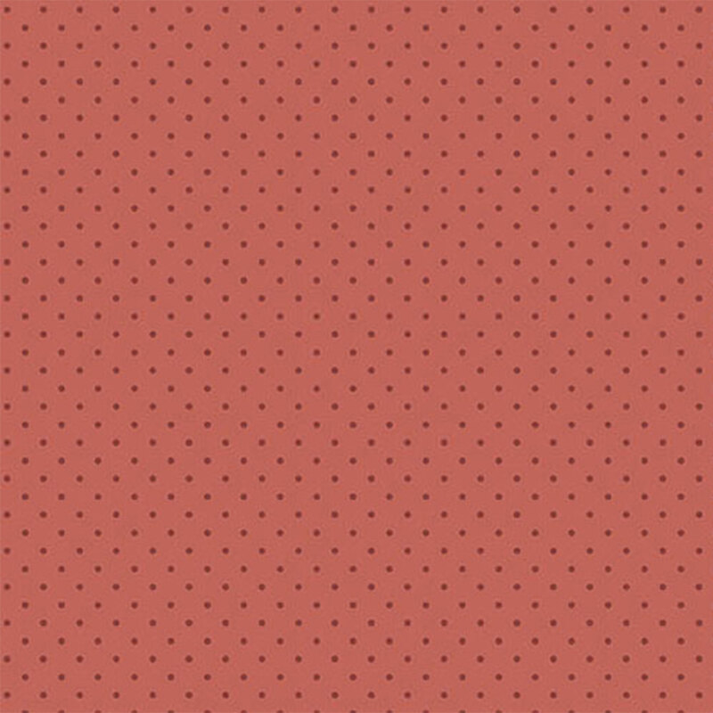 A fabric in a muted coral color with evenly spaced black polka dots.