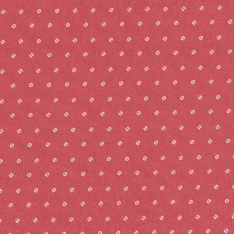 Red fabric with a repetitive white polka dot pattern across the surface.