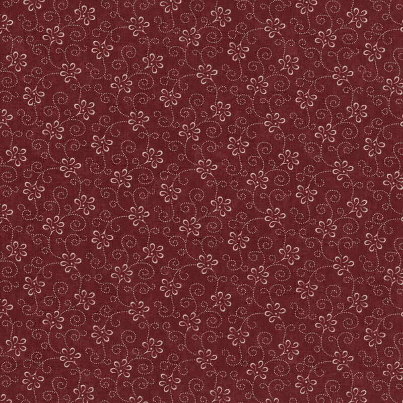 Red patterned fabric featuring swirling designs and small flowers on a deep red background.