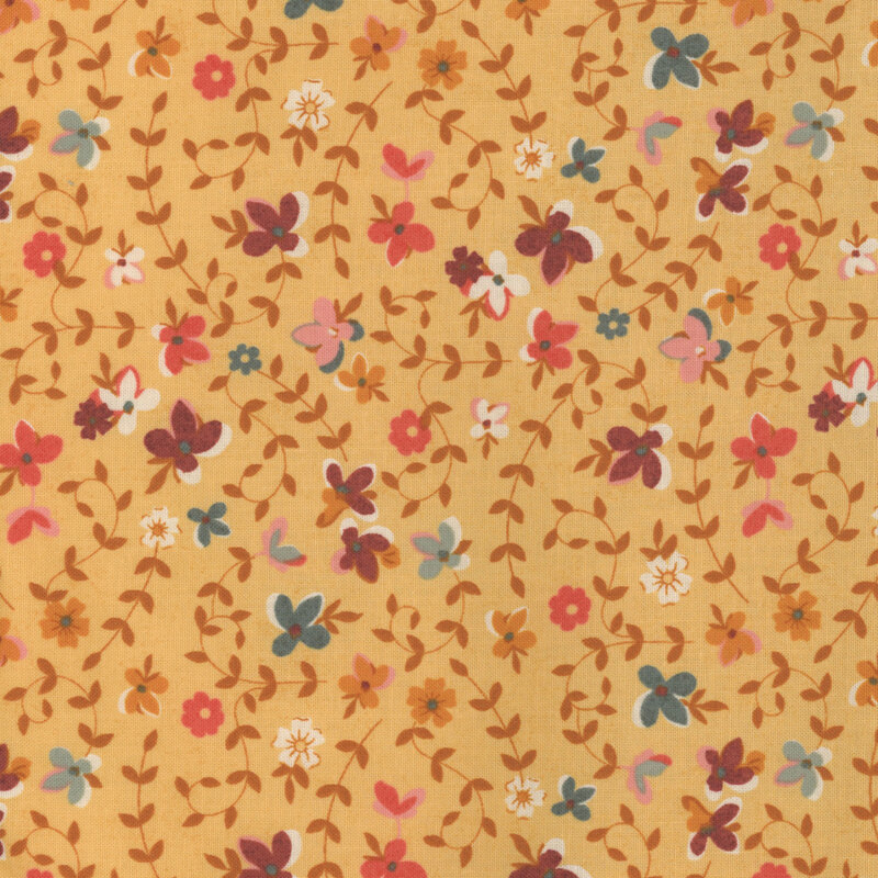 Yellow-orange fabric with scattered flowers and sprawling vines.