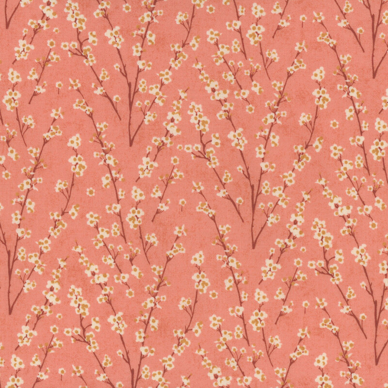 Pink fabric covered with delicate branches and cream flowers, creating a floral pattern.