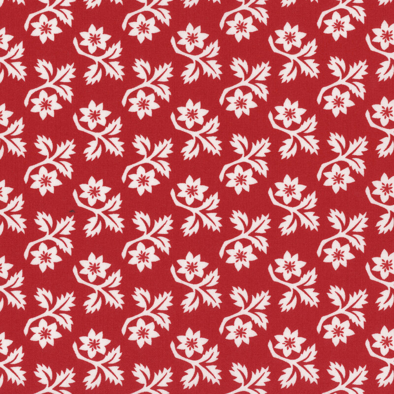 Red fabric with rows of white angular leaves and flowers with red centers.