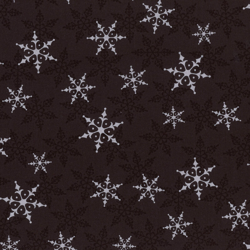 Black fabric with white and tonal snowflakes tossed across the design.