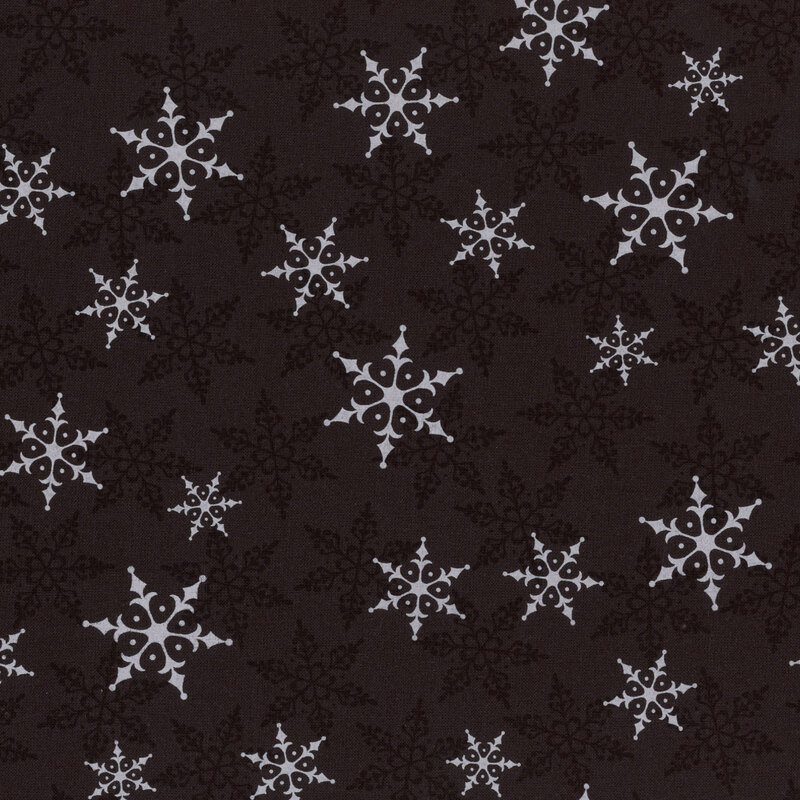 Black fabric with white and tonal snowflakes tossed across the design.