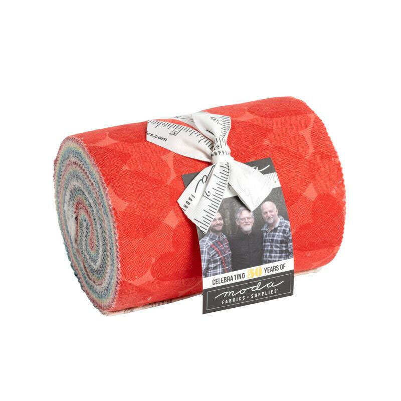 Colorful fabric roll wrapped with a ribbon, featuring a tag celebrating Moda's anniversary.