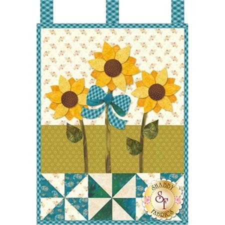Three yellow sunflowers with a large teal ribbon and teal pinwheels.
