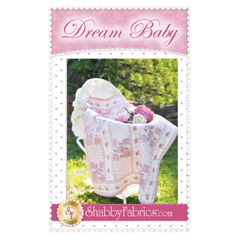 pink floral stripe nine-patch quilt draped over bassinet.