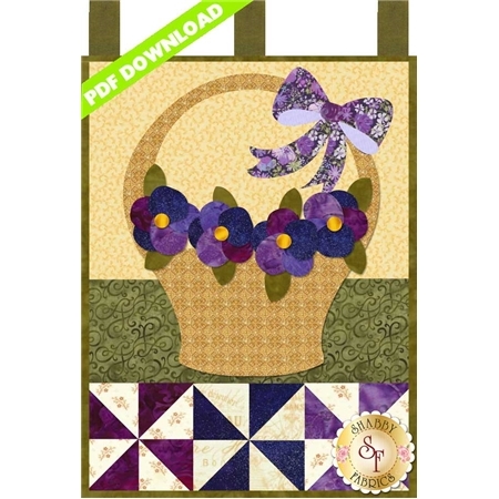 Tan basket filled with purple pansies and decorated with a purple ribbon.