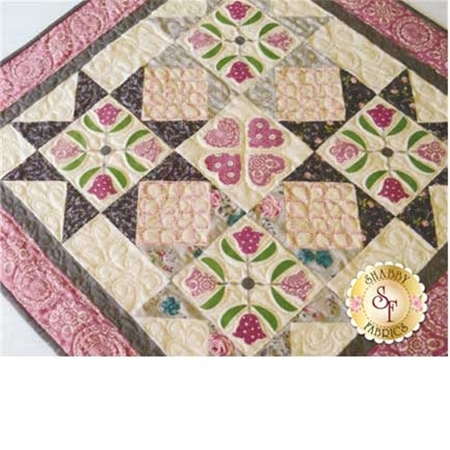 Baltimore album style mini quilt in cream and brown with pink accents and border.