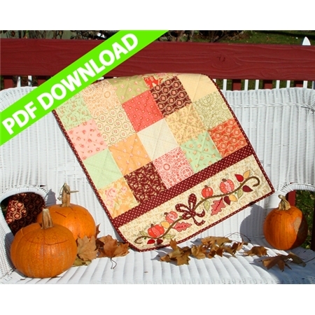 Table runner made from orange and pale brown patchwork squares with pumpkin vine applique on end.