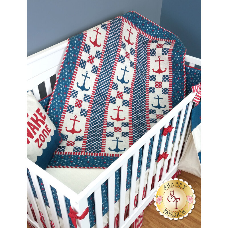 Red and blue nautical themed pieced quilt with staggered anchor applique shapes.