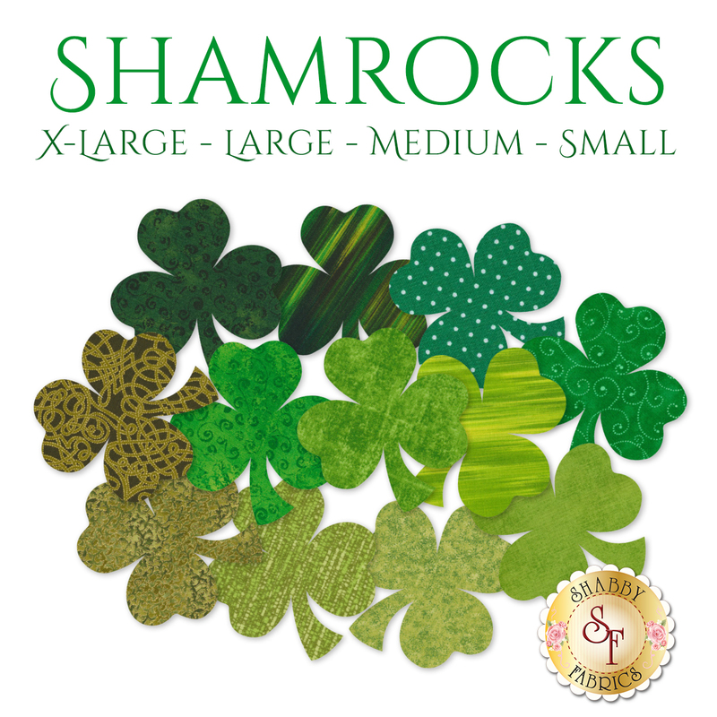 12 shamrock applique shapes in a variety of green and dark green print fabrics.