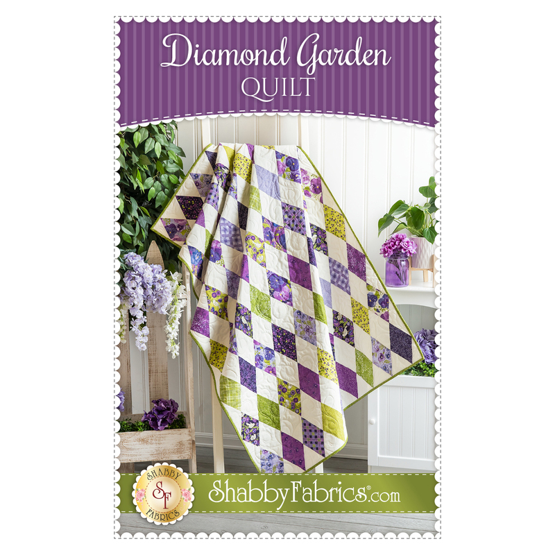 front cover of Diamond Garden Quilt pattern by Shabby Fabrics, featuring a quilt with white, purple, and green diamonds draped over a ladder