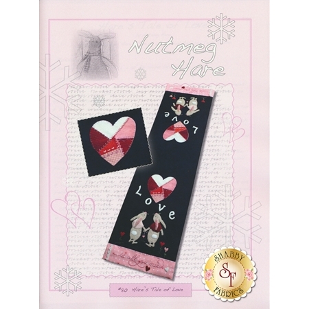 The front cover of Hare's Tale Of Love Pattern showing the finished table runner with two bunnies and a patchwork heart.
