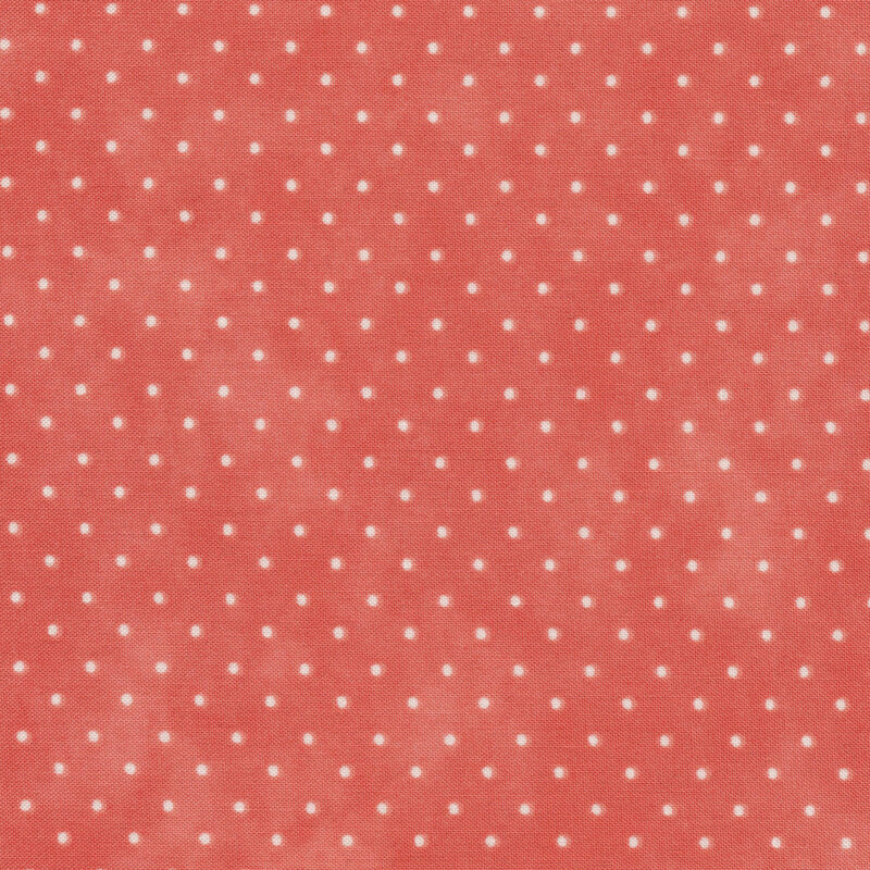 Fabric featuring tiny cream polka dots on mottled pink
