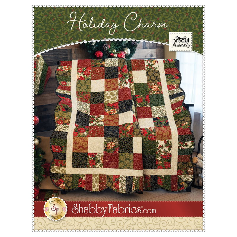 A red, pale green, and pale blue patchwork quilt made from charm squares with a scalloped border.