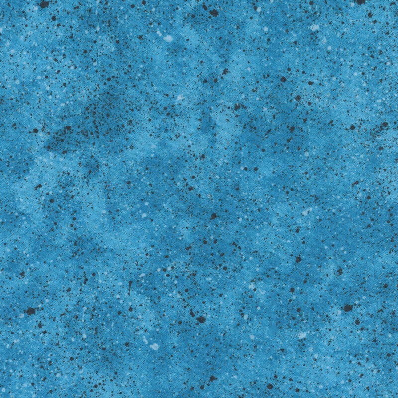 Discolored warm blue fabric with speckled black and sky blue spots 