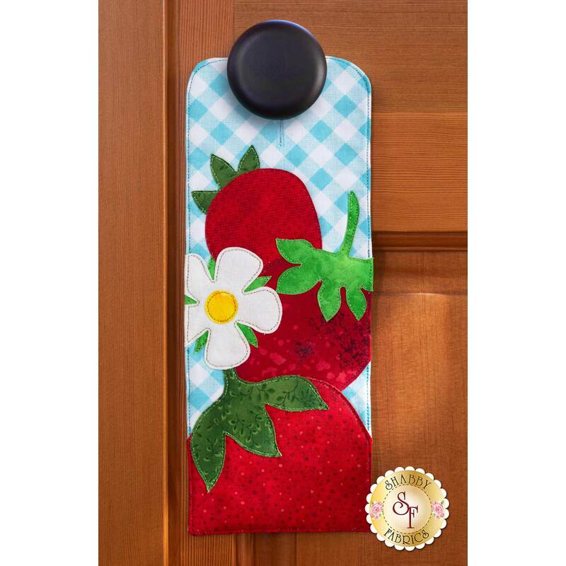 Door hanger kit for A-door-naments June with three red strawberries and strawberry blossom on blue.