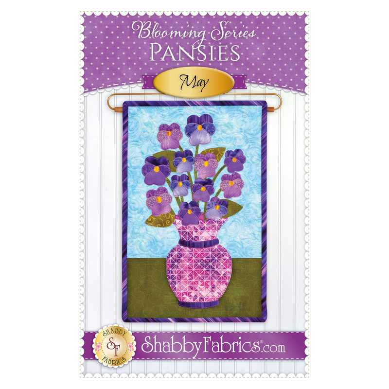 The front of the Blooming Series - May pattern by Shabby Fabrics showing the finished project with a bouquet of purple pansies.