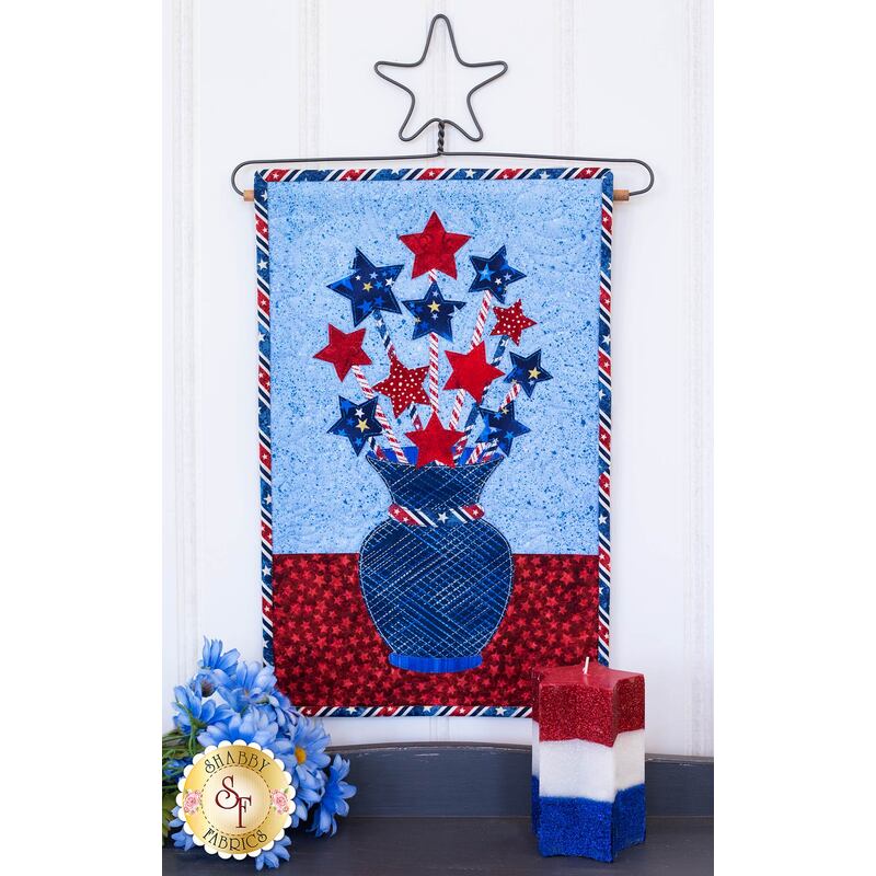 Red and blue five-pointed stars on red striped straws in a blue striped vase.