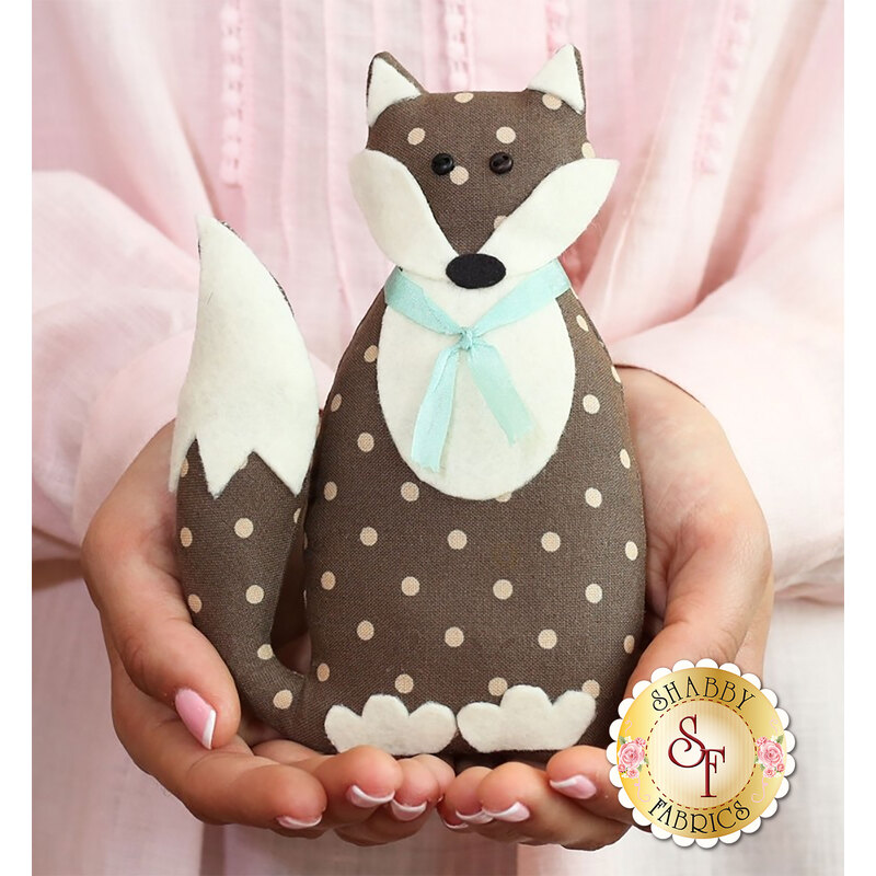 Foxly Petite Pattern front cover featuring the finished stuffed fox with a light blue ribbon around his neck.