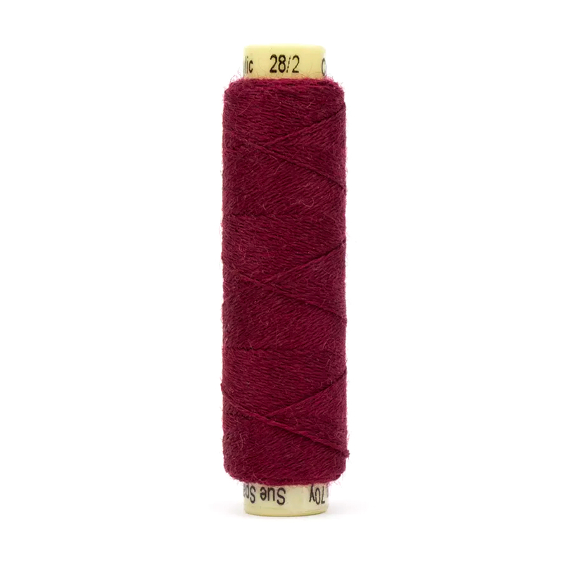 A spool of the Ellana EN44 - Bordeaux thread on a white background