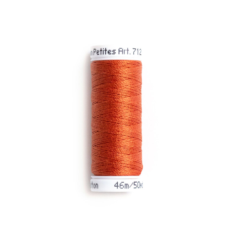 A spool of Sulky 12wt Cotton Petite #0621 Sunset thread on a white background