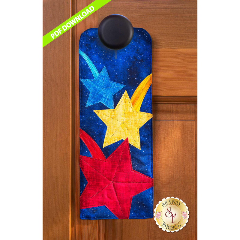 PDF Pattern for A-door-naments July with blue, yellow, & red shooting stars on deep blue fabric.