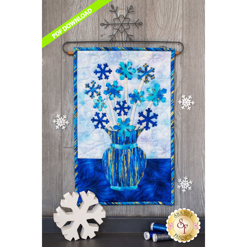 Blue snowflakes on white stems in a blue streaked vase.
